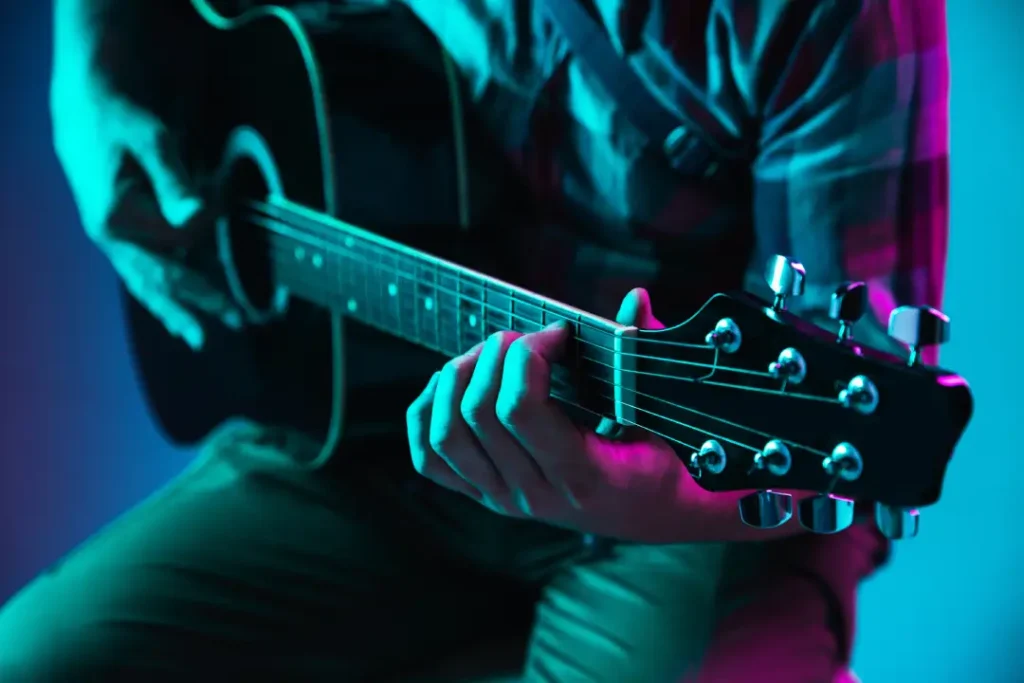 cerca mano guitarrista tocando guitarra macro concepto publicidad aficion musica festival entretenimiento persona que improvisa inspirada copyspace insertar imagen o texto neon colorido iluminado